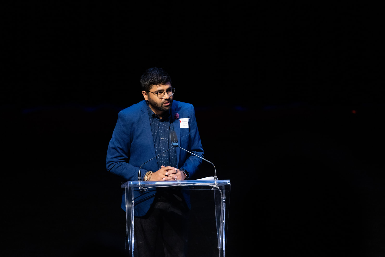 Zain Velji speaks at a podium at the 2023 Annual General Meeting.