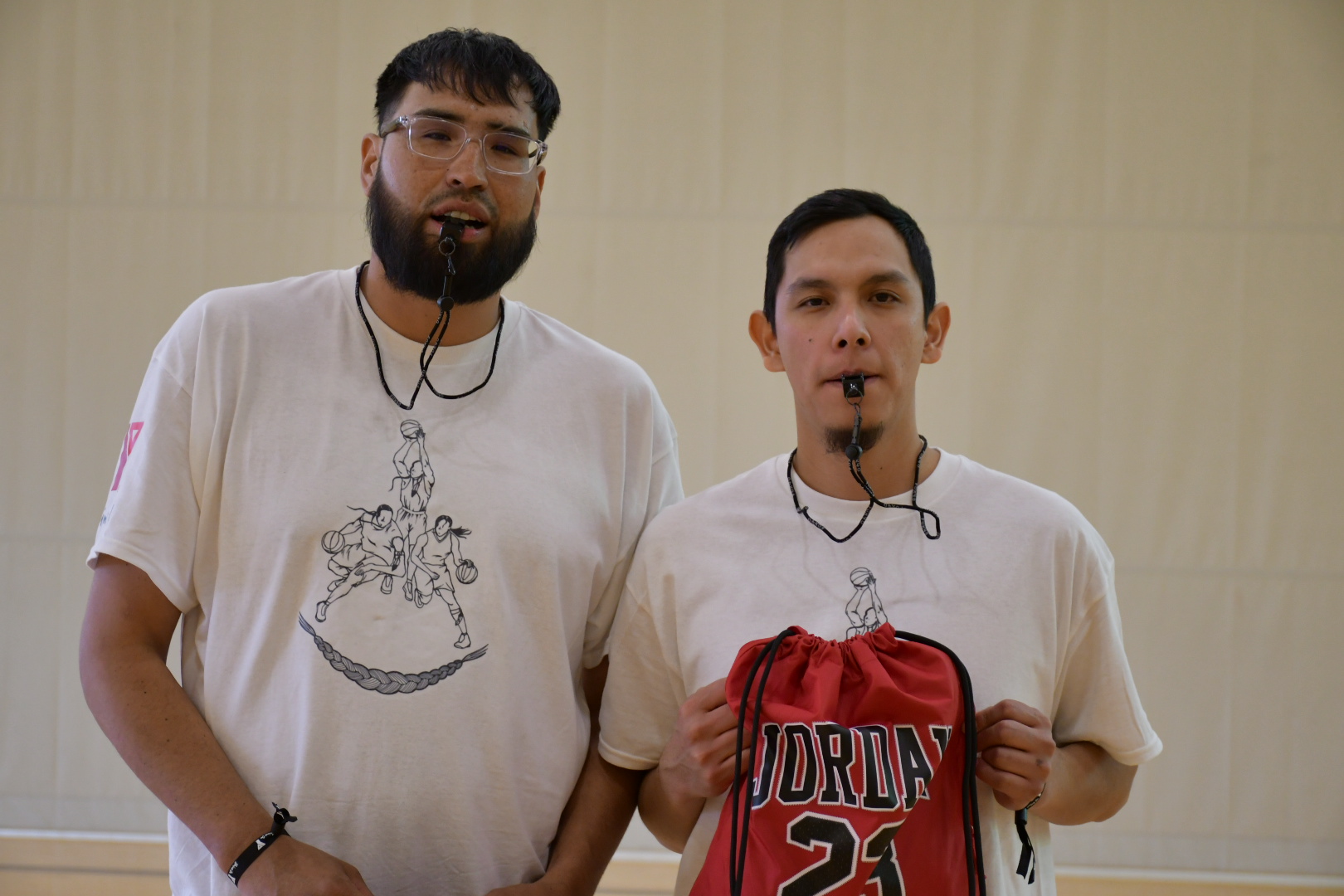 Two youth hoops tournament referees pose for a photo