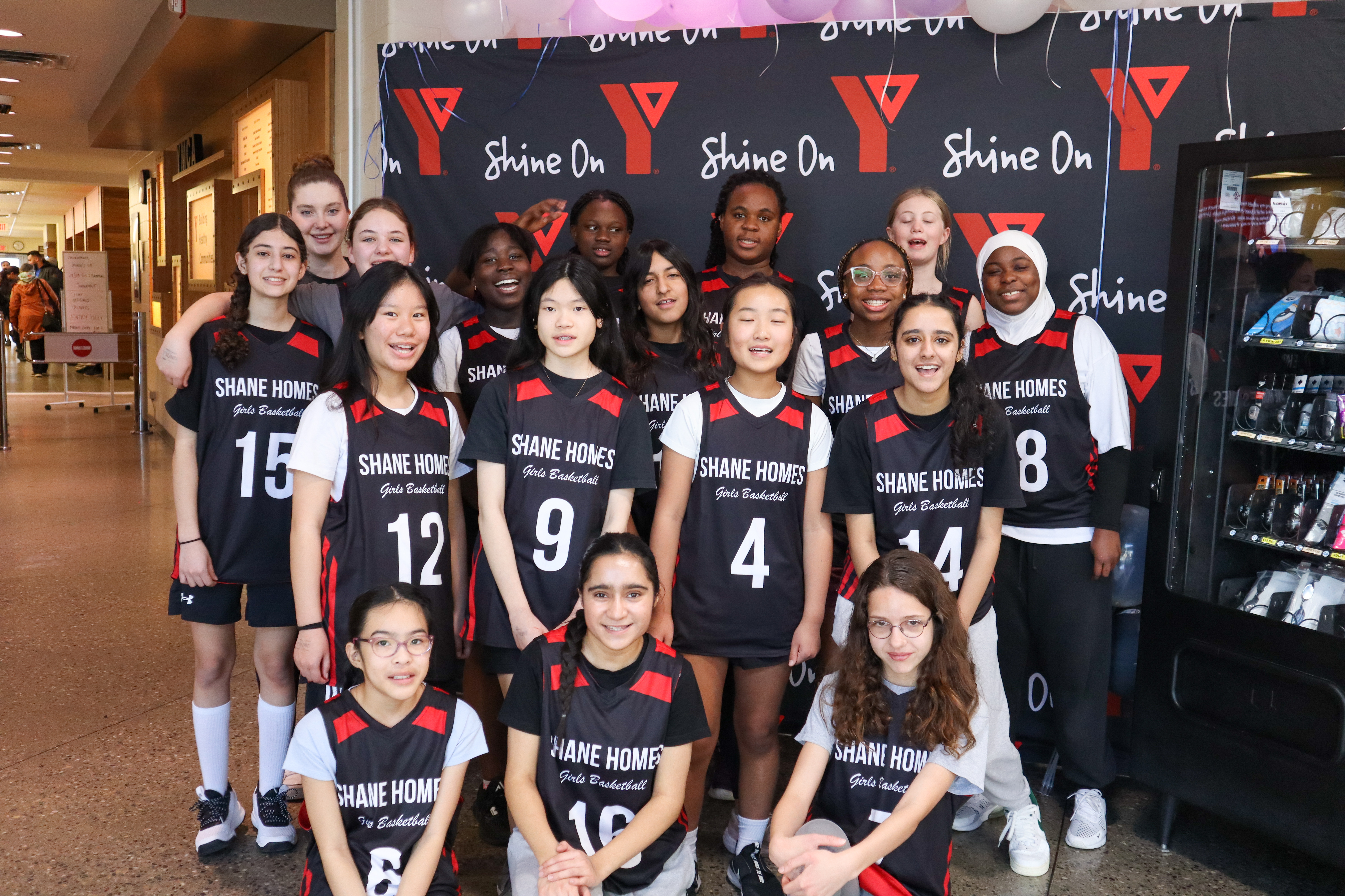 A girls basketball team poses for a group photo at the YMCA basketball tournament