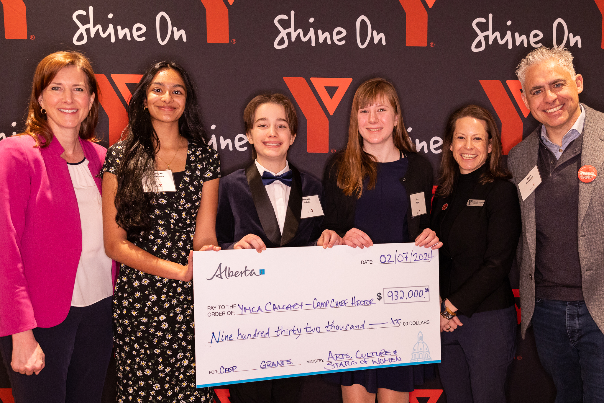 A group of YMCA staff and volunteers pose with the Government of Alberta staff for a cheque presentation