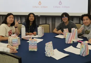 Group of youth sitting around a table smiling