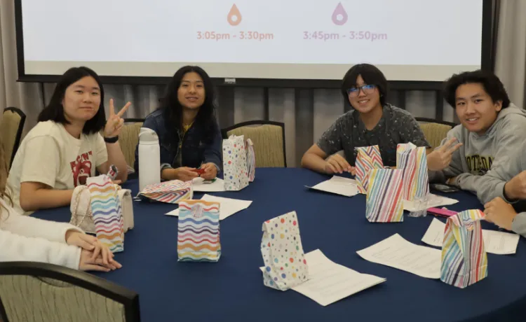 Group of youth sitting around a table smiling