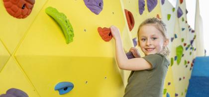 little girl playing on climbing wall