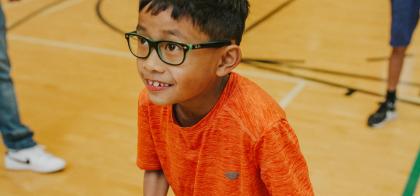 Little boy looks eagerly at baskerball hoop