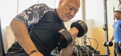 Senior lifting a dumbbell at YMCA Calgary Gym Weight floor