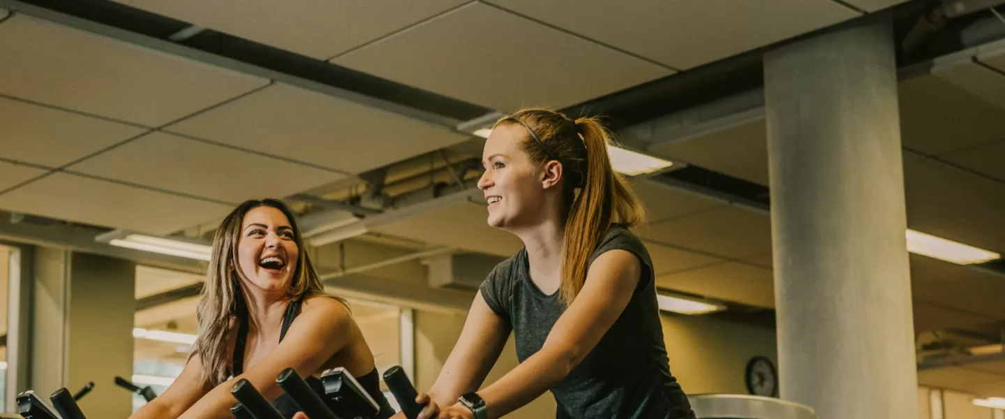 two individuals on exercise bikes