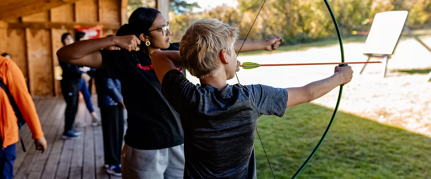 Youth shooting arrow at Camp Riveredge YMCA