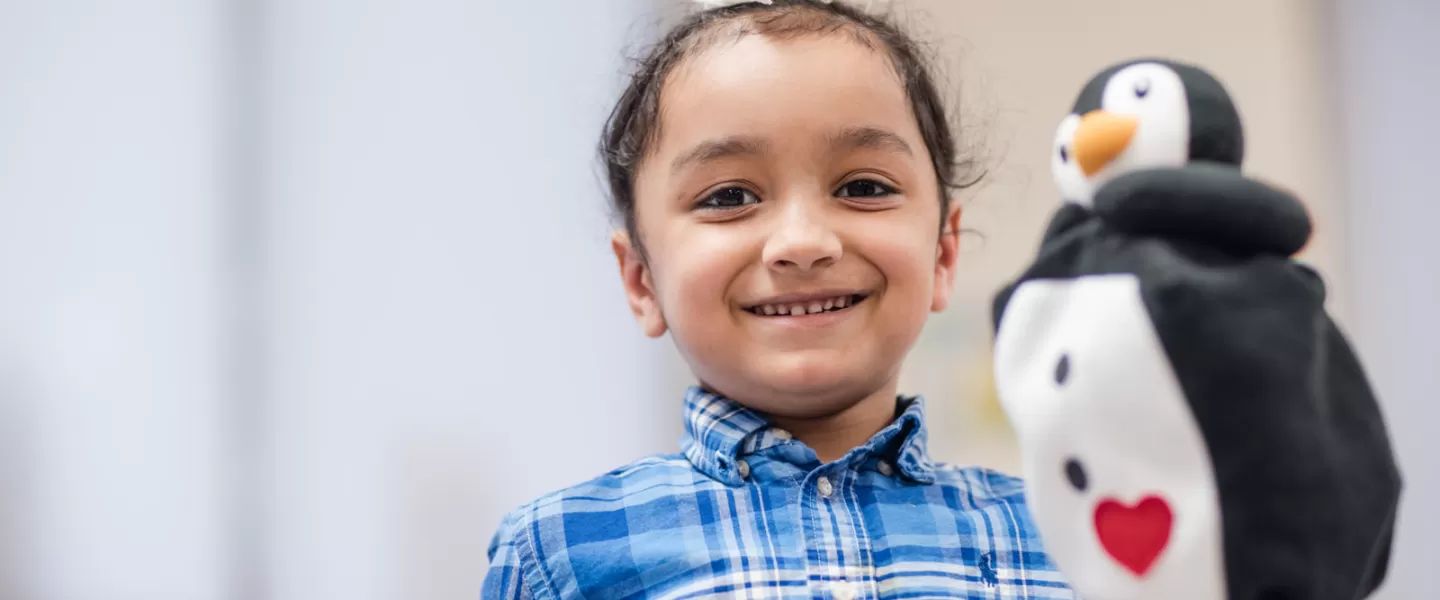 Girl holding a penguin hand puppet