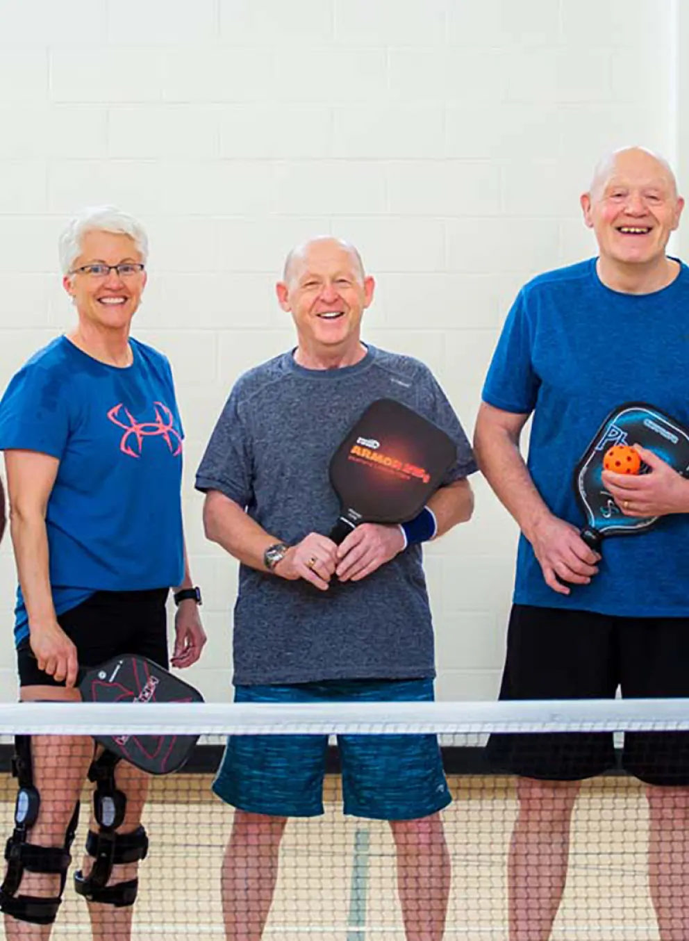 group of older men play pickle ball