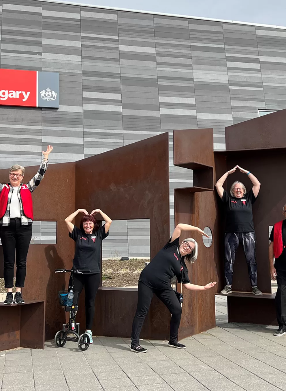 Volunteers outside of branch doing YMCA with arms