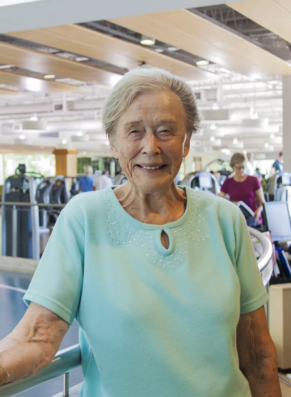 older woman smiling on indoor track