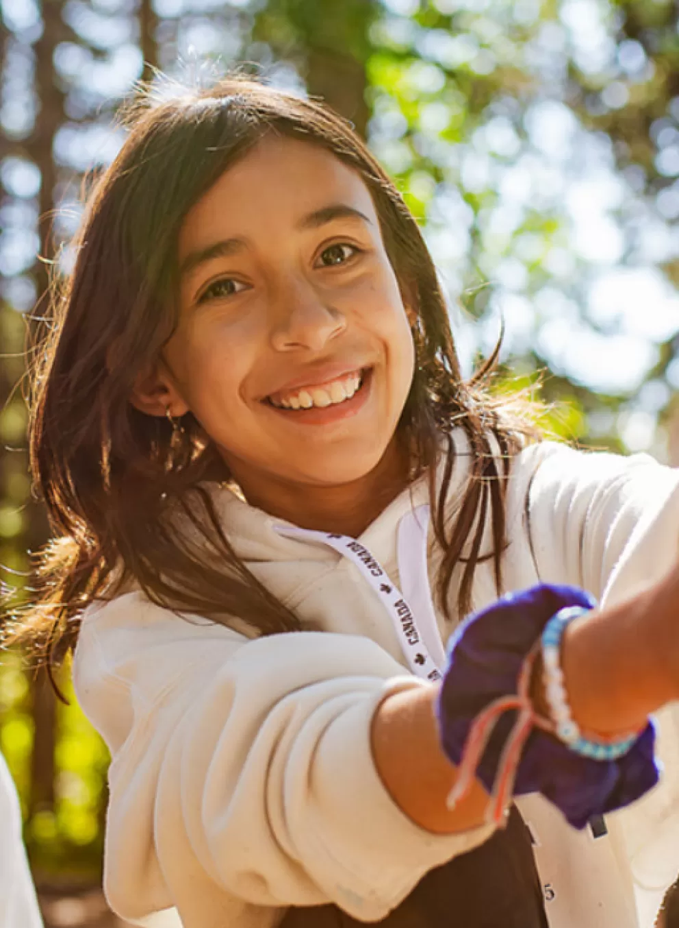 A young girl smiles while trying out the challenge course