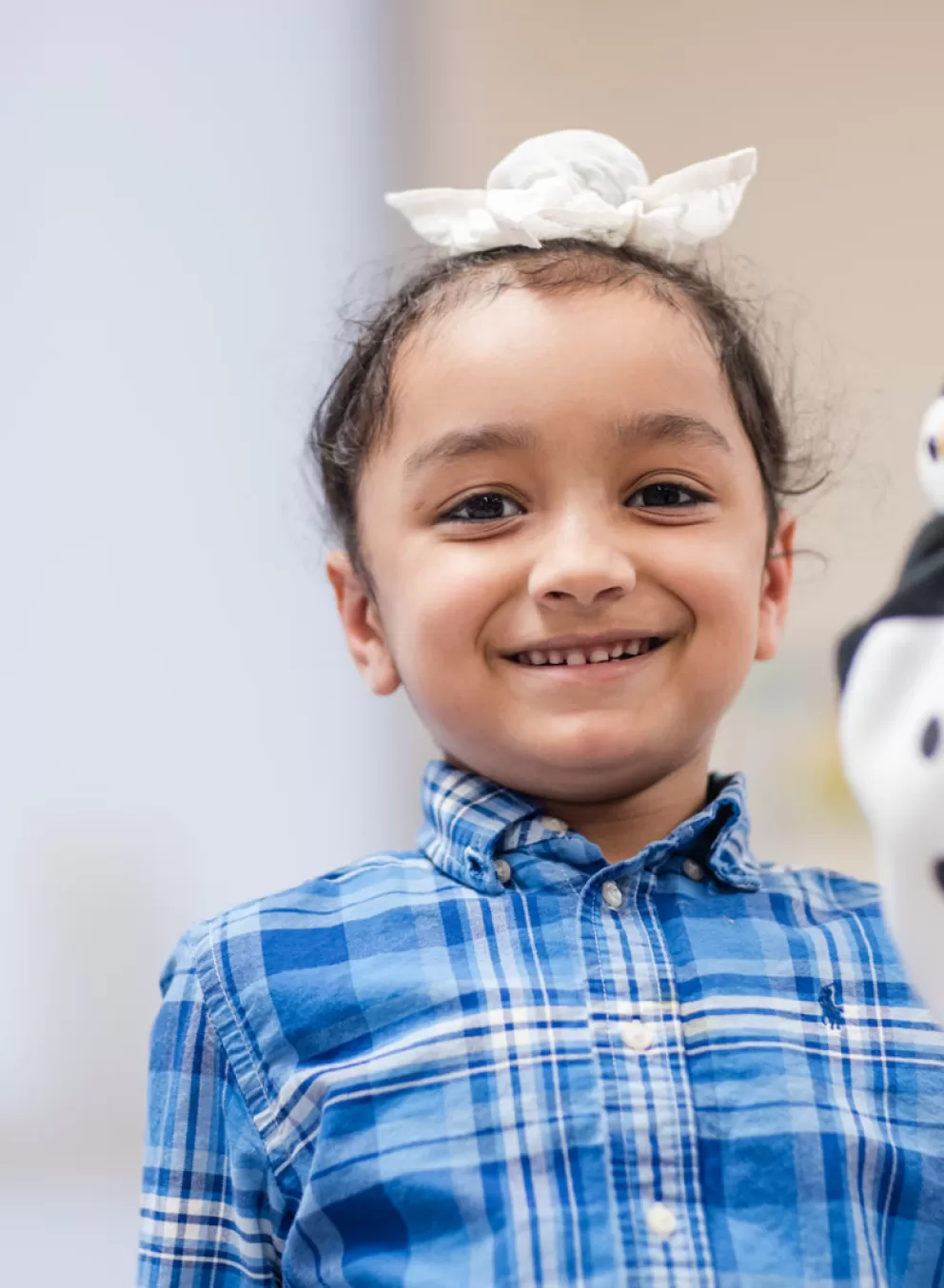 Girl holding a penguin hand puppet