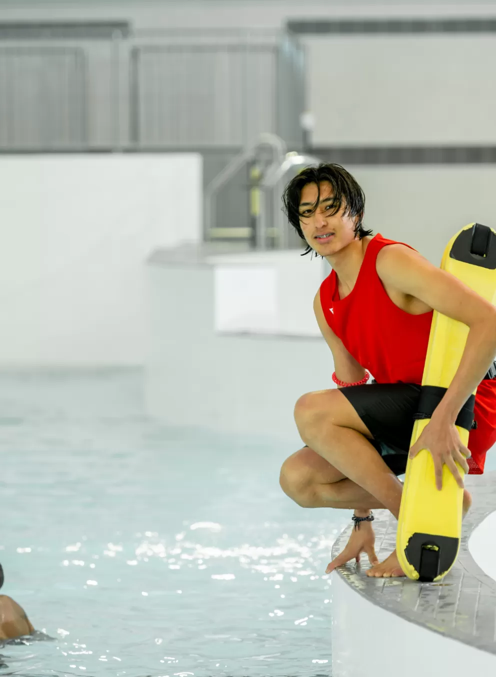 Male lifeguard in the pool with kids