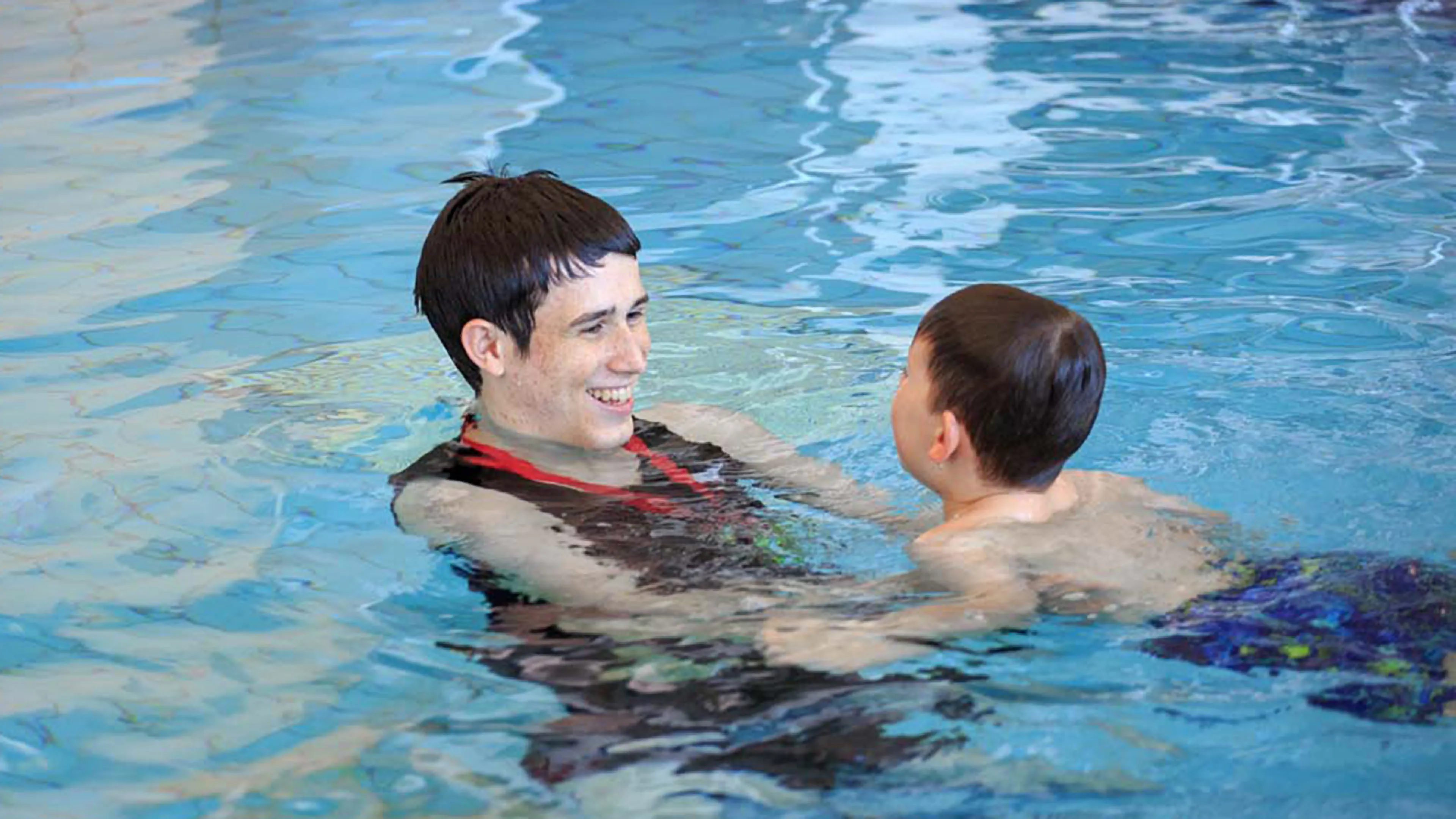 swim instructor with child in pool