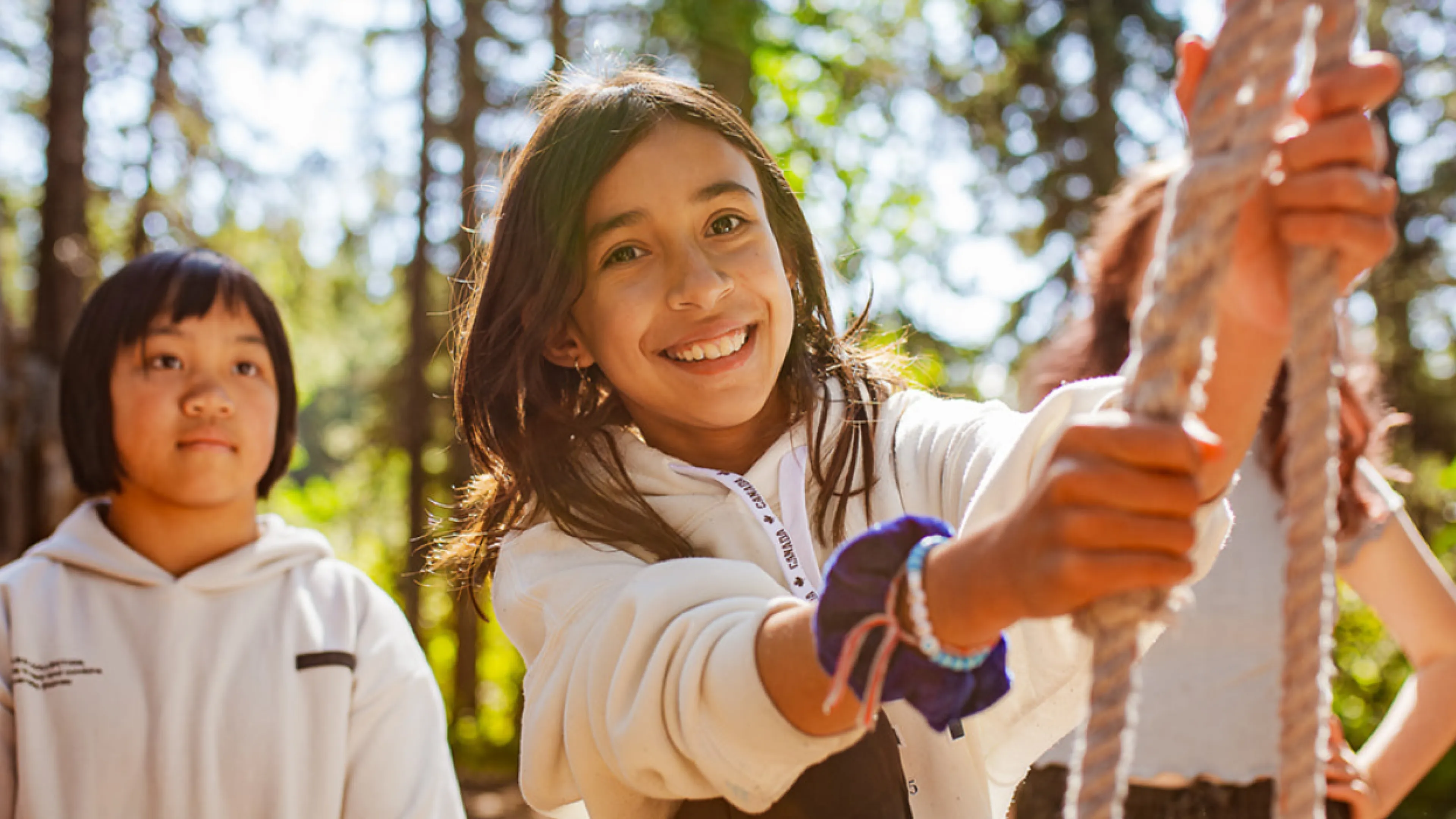 A young girl smiles while trying out the challenge course