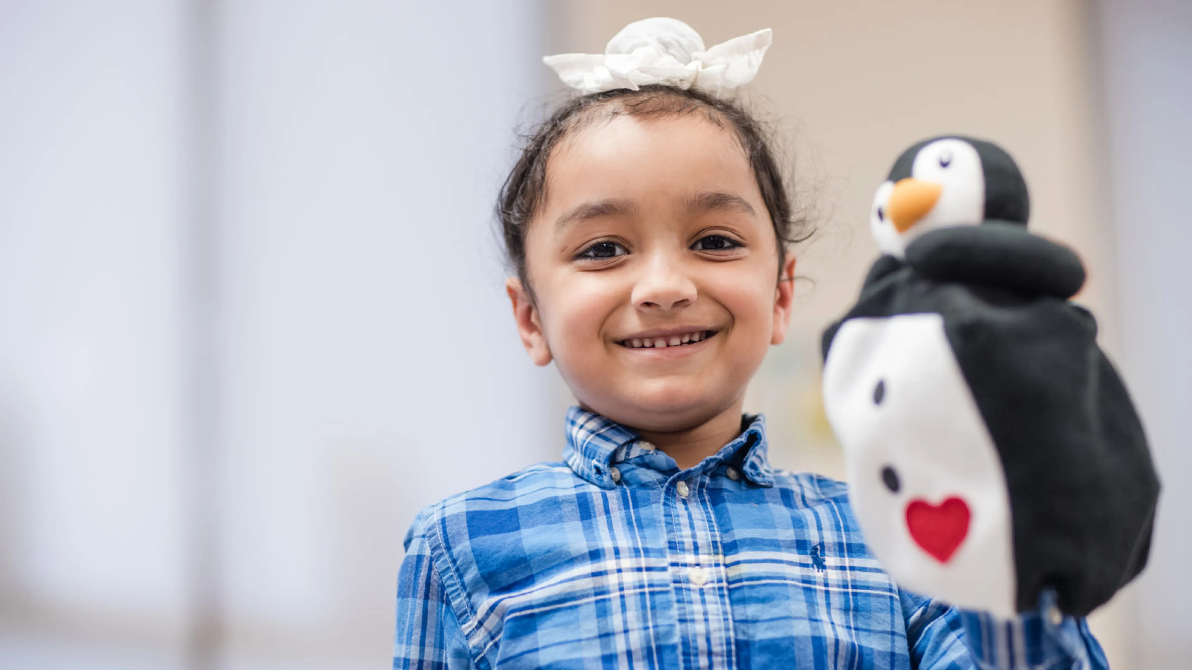 Girl holding a penguin hand puppet