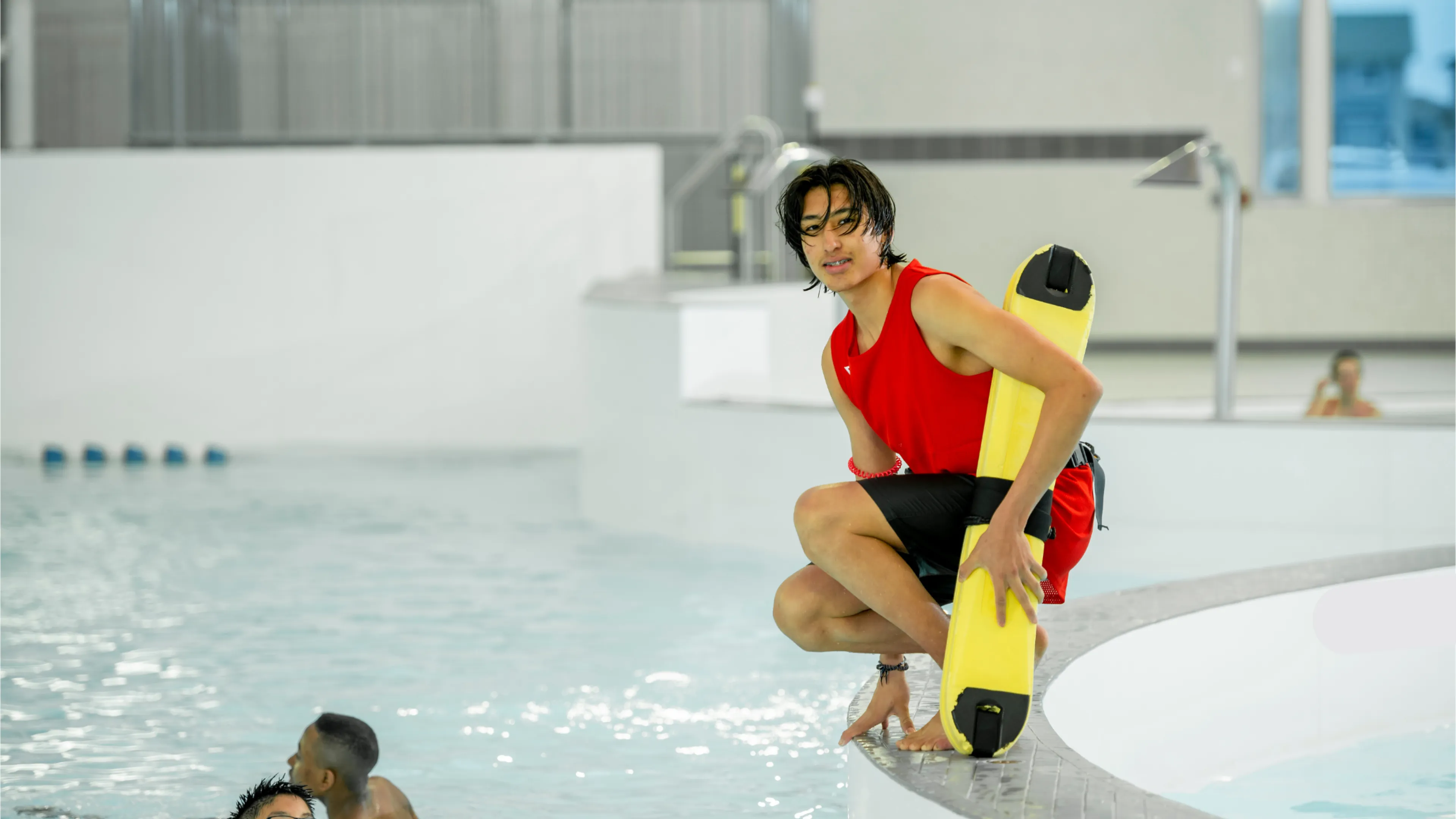 Male lifeguard in the pool with kids