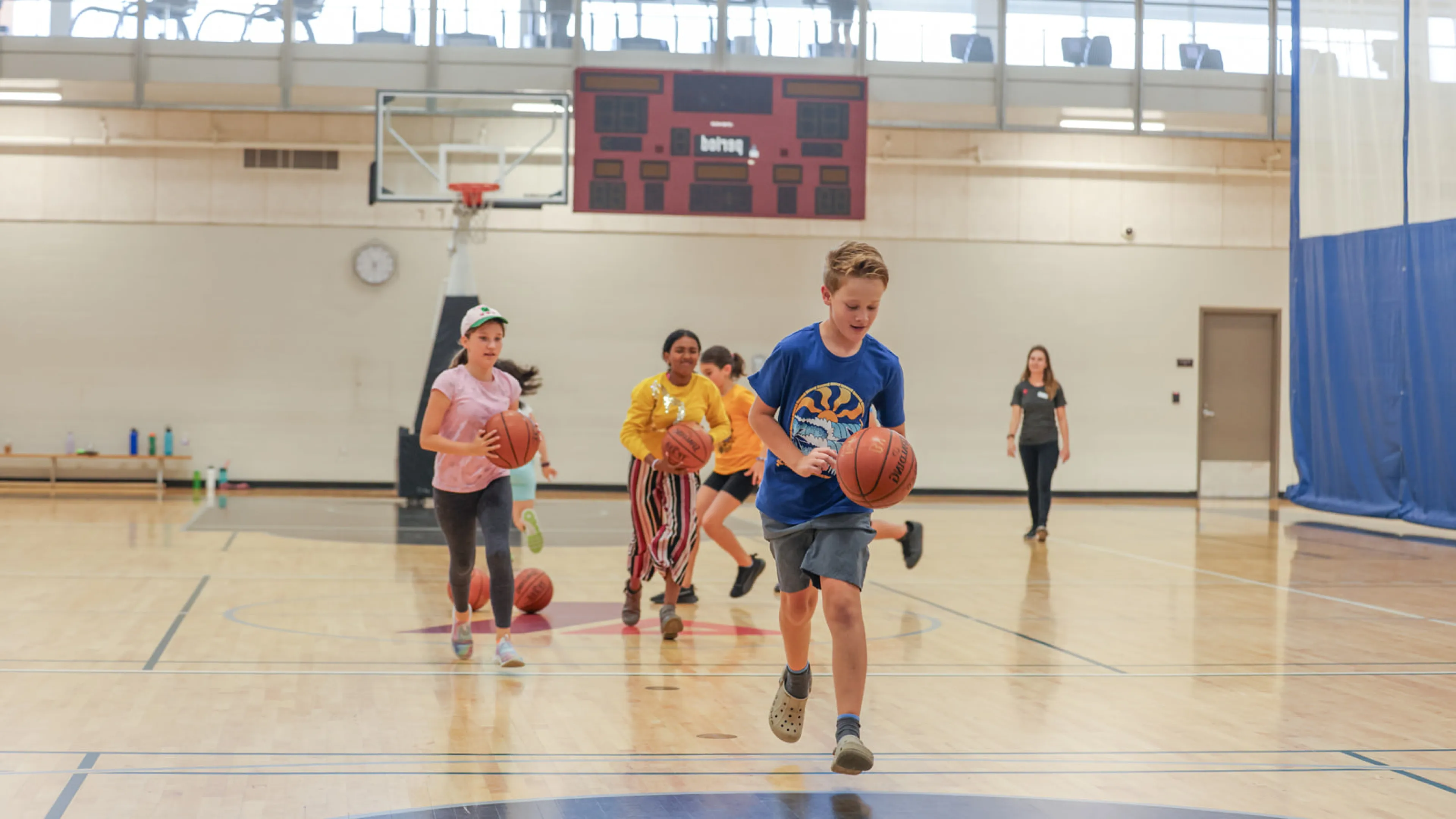 Kids in the gynesium playing basketball 2