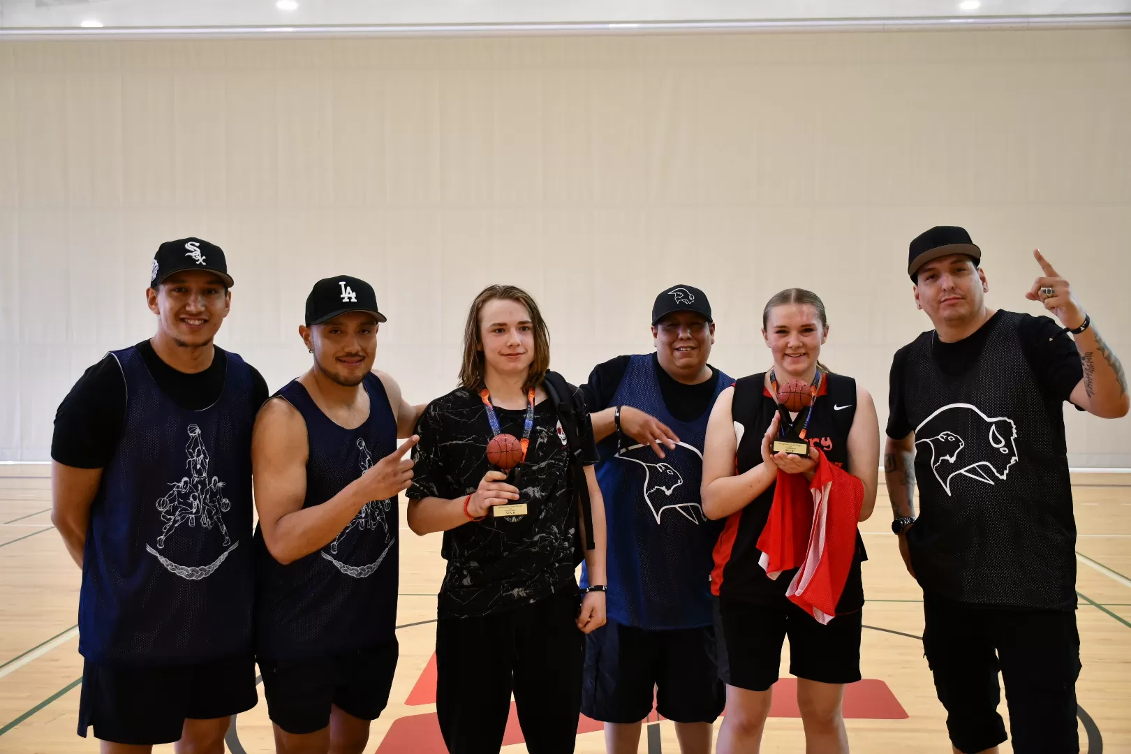 A group of youth pose for a photo as MVPs from the basketball tournament