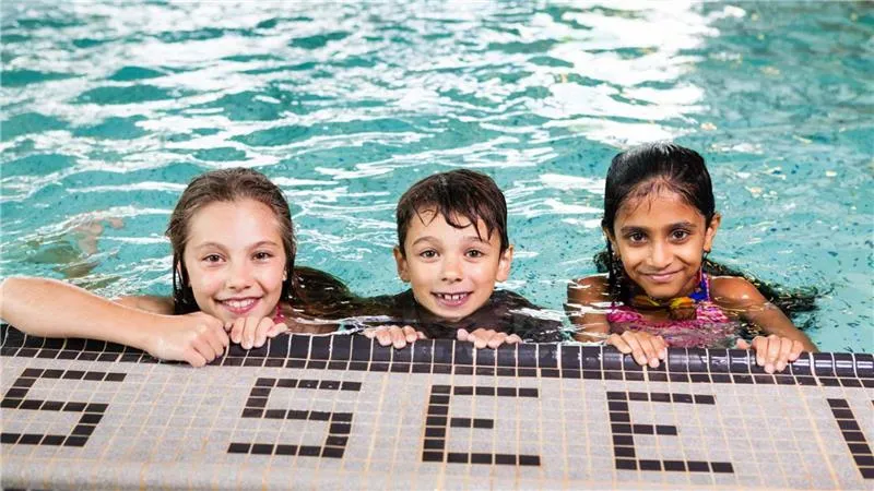 Fall Program Registration - 3 smiling kids in the swimming pool