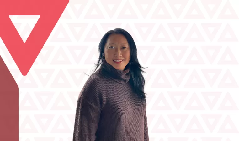 YMCA Calgary donor Eva Kwan showcases a smile on a YMCA triangle background