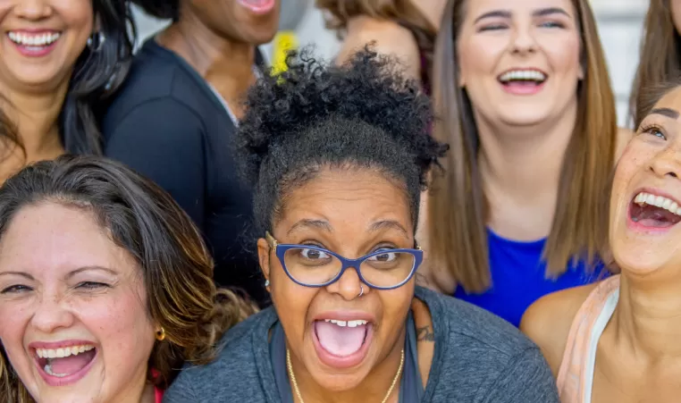 A group of women come together for a photo in a workout class