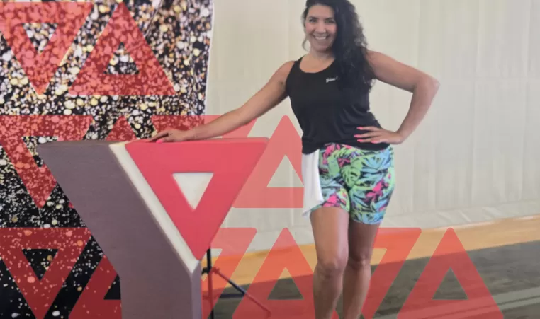 Aphrodit standing next to the YMCA symbol
