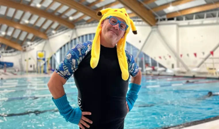 Man with glasses wearing a pikachu hat in front of a pool