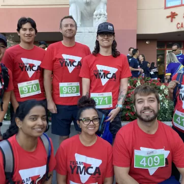 Team YMCA is ready to hit the 5K run, wearing their red YMCA shirts and runner numbers.