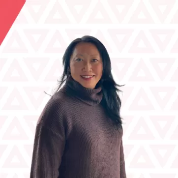 YMCA Calgary donor Eva Kwan showcases a smile on a YMCA triangle background