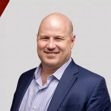 Ed Rihn poses for a headshot on top of a graphic background