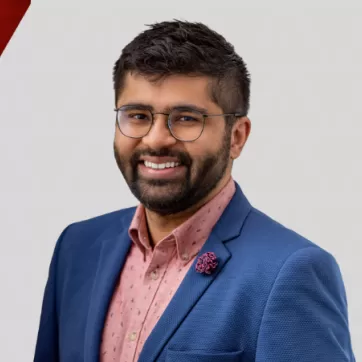 Zain Velji poses for a headshot on a graphic background