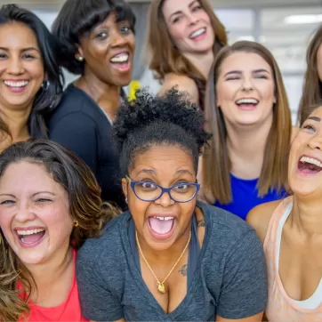 A group of women come together for a photo in a workout class