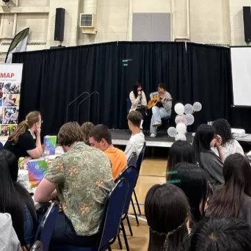 Two YMAP students perform in front of their peers at the YMAP Year-end event.