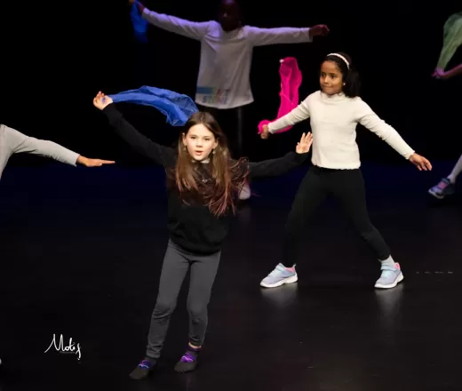 Young children dance on stage