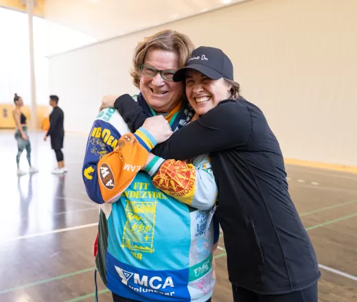 Kaia and Janet, a volunteer of over 30 years, hug at the Fitness Conference