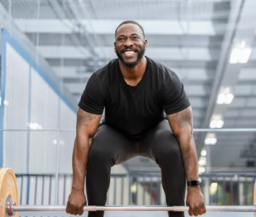 man lifting weights looking at camera