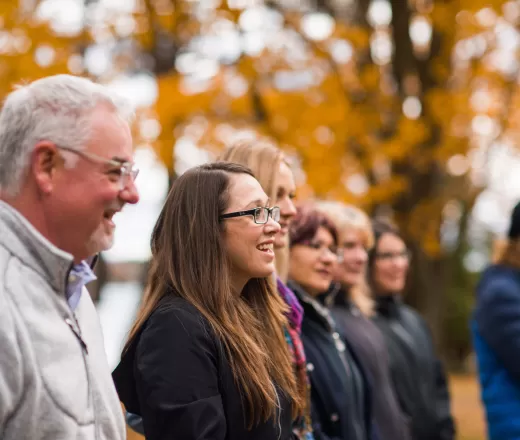 A group of people standing outdoors in the autumn.