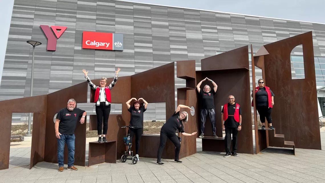 Volunteers outside of branch doing YMCA with arms