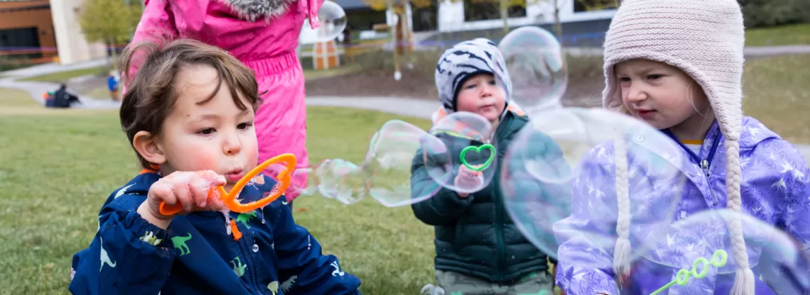 three children blowing bubbles