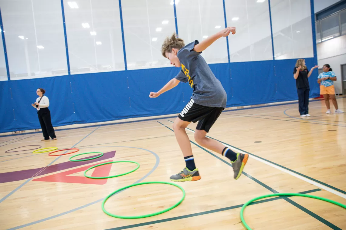 Kid jumping through a hoop
