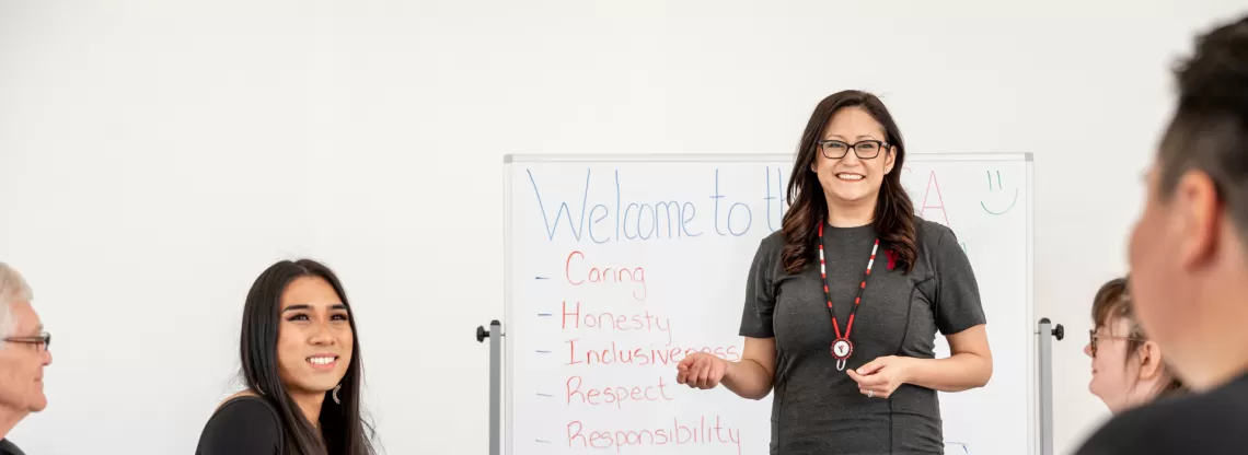 A group of people in a classroom setting, all smiling