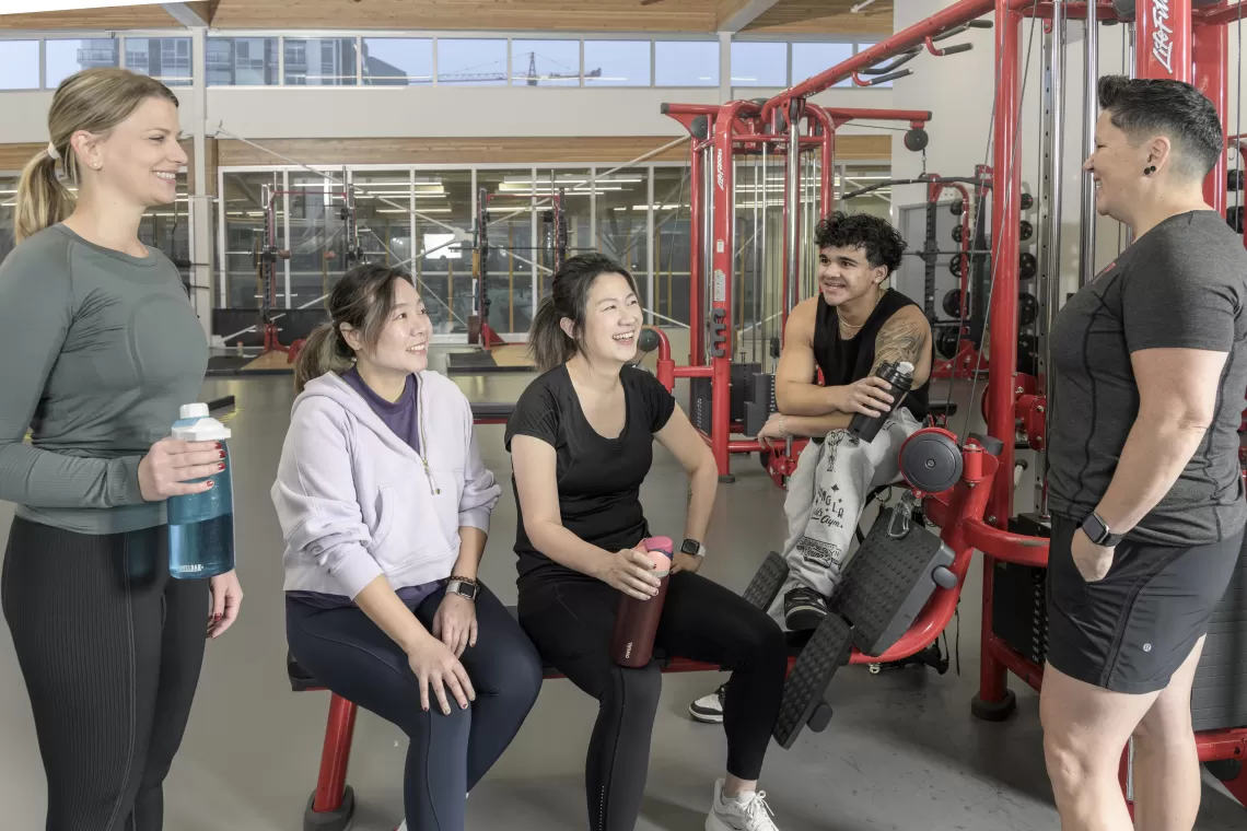 Personal trainer and, ladies and a man on the weight floor
