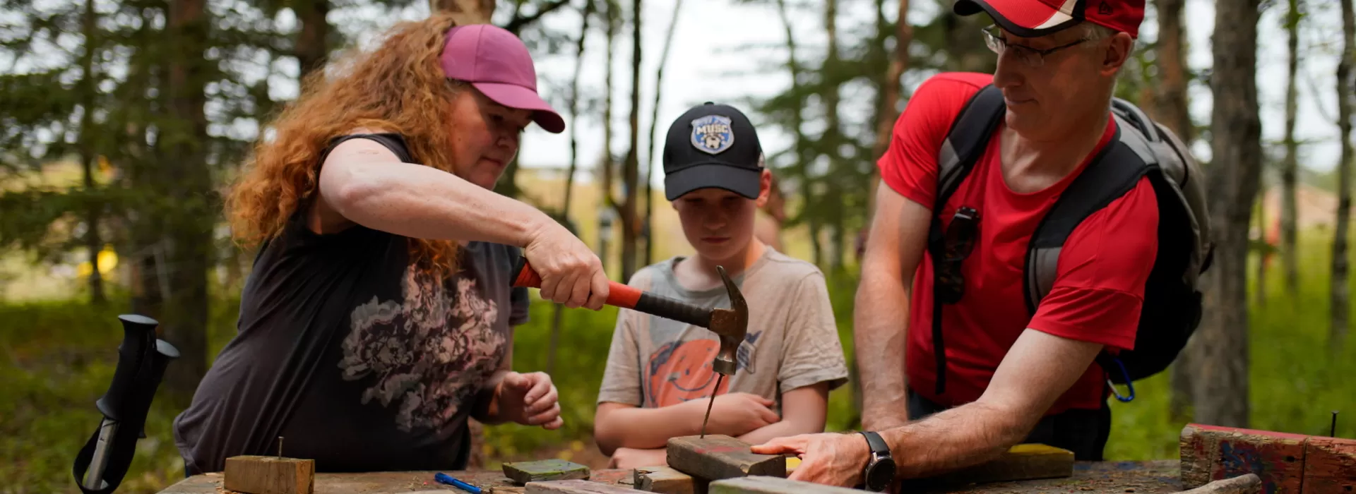 Family hammering nails into wooden blocks