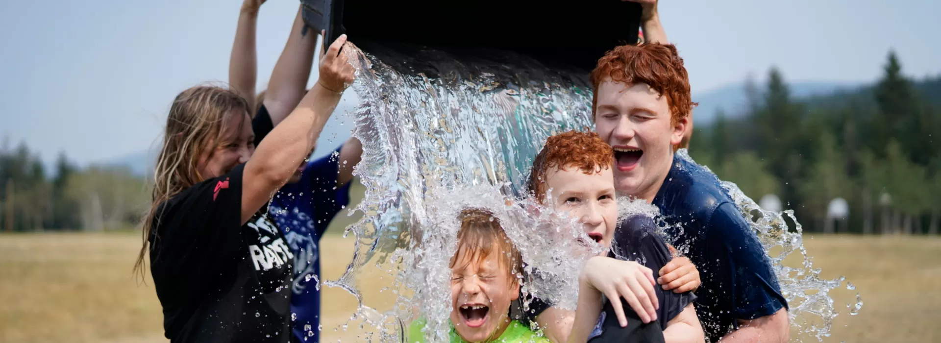 Water Bucket being poured onto children, laughing