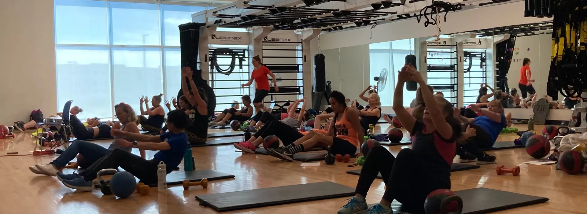 grouo of people attending a fitness class with weights
