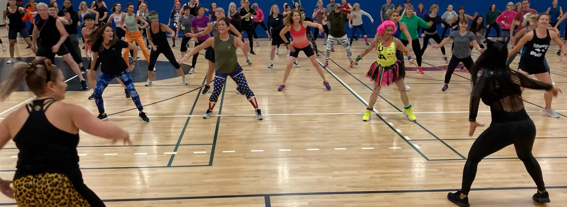 group of people doing a music based dance fitness class in a gymnasium