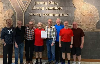 A group of eight older adults standing together smiling