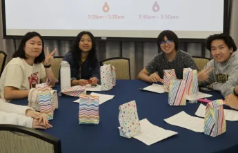 Group of youth sitting around a table smiling
